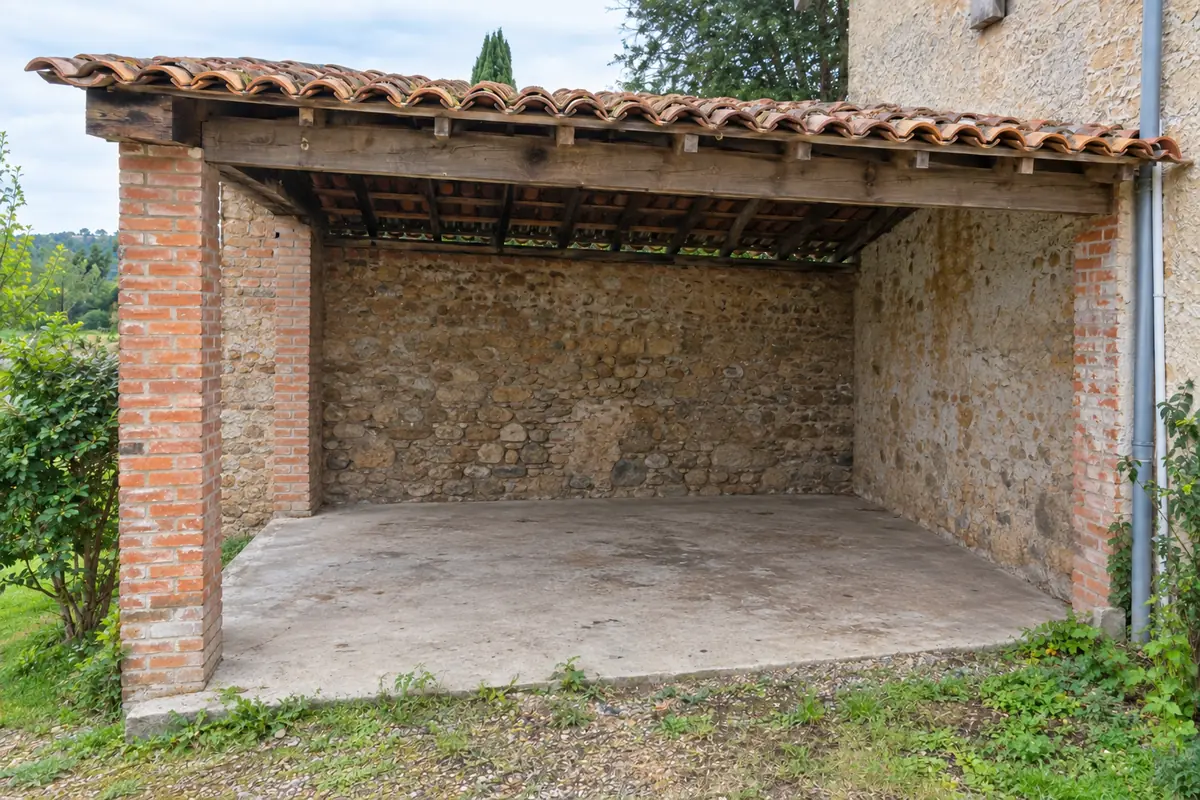 Le même appentis vidé, dalle de béton balayée, après le débarras